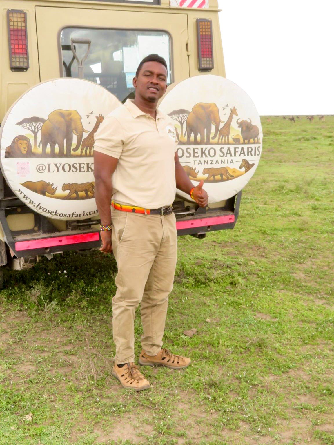 Jackson Lyoseko beside a Lyoseko Safaris vehicle in Tanzania